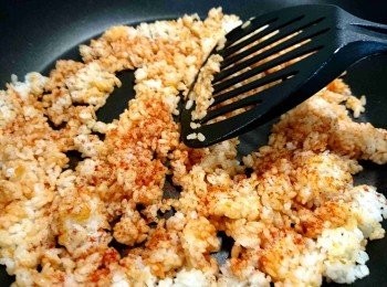 step10: 同一個平底鍋，倒入白飯，淋蕃茄醬，灑匈牙利紅椒粉，用鍋鏟將飯撥鬆（鏟面與鍋面呈約45度角，不要平行重壓，圖示說明： https://goo.gl/5CradF ）。