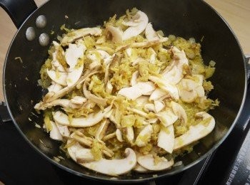 step2: 步驟2：
熱鍋先倒入100公克洋菇片，乾煸至水分揮發略帶香氣後取出備用，鍋中放入奶油，融化後轉小火，先將洋蔥炒軟，加入蟹肉和蟹腿拌炒，再放回炒過的洋菇片及白酒炒個2至3分鐘。