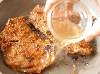 step6: 再把豬頸肉翻面，下蜜糖水，調至小火，蓋上煮5分鐘，翻面後再次蓋上，多煮5分鐘。