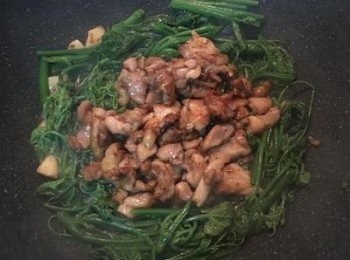 step6: 龍鬚菜炒煮的差不多之後，便可把雞肉放入拌炒，延鍋邊倒少許米酒燒煮以增添香氣，湯汁煮滾即可起鍋。由於雞腿肉的醃料中含有太白粉，因此收汁後，醬汁會類似勾薄芡ㄧ樣。