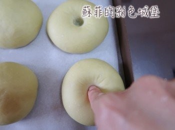 step10: 用手指壓進將麵團中央後，噴些水在麵包表面後，再灑些黑芝麻裝飾。 大膽給他從中間搓下去，絕對不會變形喔！
