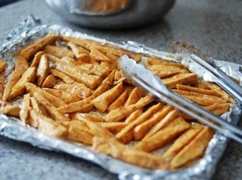 step2: 將地瓜條放在大碗內，下橄欖油及所有調味料拌勻，放在烤盤上，地瓜不要重疊