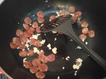 step5: 用少許油爆香臘腸片及蒜蓉。