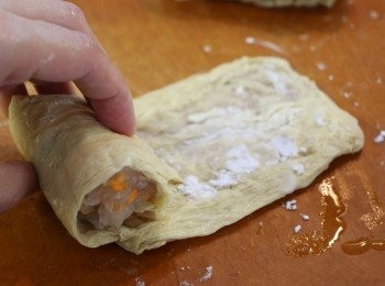step9: 取適量蝦蓉放在豆包皮的一端，然後捲起來，尾端可以灑上少許粟粉黏合。