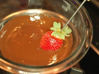 step4: 此時再將融化巧克力加熱至32度c(維持這個溫度,能表現出巧克力最佳的品質)。由於可可脂的結晶特性，必須經過「調溫」(temper)才會呈現光亮、硬脆、化口性好等特質。簡單來說，調溫是一種將巧克力融化後，將溫度升高再降低，藉以穩定巧克力的技巧。 1.將草莓用叉子固定好,沾上融化巧克力。