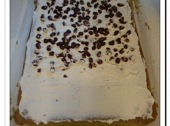 step11: 沒斜切的一邊放近自己, 在蛋糕上抹上一層忌廉, 近自己一方塗厚一點。
放上蜜紅豆粒。近斜切一方三分一位置不用放。