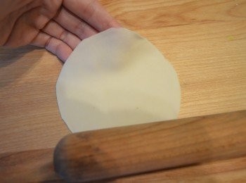 step15: 取一個小麵團，切口向上，用手掌壓扁，再用擀麵棍擀成圓形的薄片，擀得愈薄愈會好吃。擀出來的麵皮，用保鮮膜覆蓋，以防乾燥。