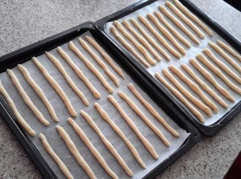 step6: 將小麵糰擀成約1/4吋粗，五至六吋長麵條，放在烘焙紙上。再用掃在面條表面塗一層蛋白