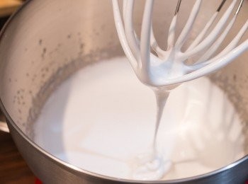 step6: 打糖漿的情況有點像打忌廉，打得時間愈久，糖漿會變得愈來愈企身。這次需要打至濃稠、會慢慢滴落的狀態，此時拉起打蛋器應清楚看到糖漿滴落的紋理但數秒後紋理會漸漸消失。起初打時因煮好的糖漿太熱，會有蒸汽，打至稍涼後可加入雲呢拿香油和檸檬汁。（我這個打了 5 分 30 秒，約以手提式的電動打蛋器可能需要比較多一點的時間。建議從 4 分鐘開始密切觀察著糖漿的狀態，不要打得過火）