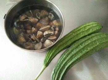 step1: 蛤蜊先加入塩巴，並以冷水吐沙約3-5小時，約1-2小時，需換水清洗再重泡吐沙至清水洗淨時吐沙時，水無泥沙、雜質即可；鍋中放入800cc的水；絲瓜【澎湖名產】洗淨並削皮，切塊，薑絲切絲，備用；