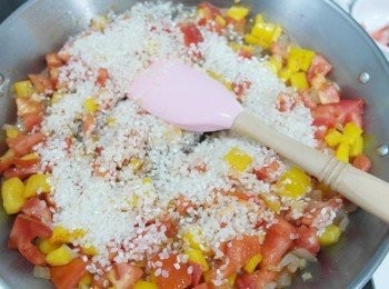 step3: 接著倒入白米炒至微微透明時撒上紅椒粉和薑黃粉拌炒!! (若家中有西班牙米或是燉飯米去煮更好吃!!)