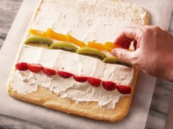 step10: 將草莓、奇異果、黃桃橫長的那面朝向自己，鋪排在鮮奶油霜上。