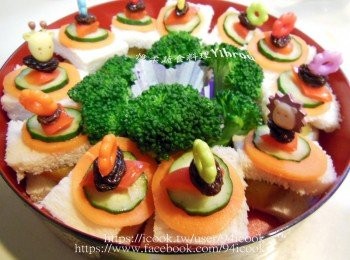 step3: <span class="group_1"><span class="group_3">食材</span>1</span>川燙熟，<span class="group_2"><span class="group_3">食材</span>2</span>蒸熟，吐司切小塊夾入小黃瓜片和地瓜，叉子依序串葡萄乾．紅甜椒．小黃瓜切片和紅蘿蔔片，再次固定到吐司上面，擺上青花菜即可。