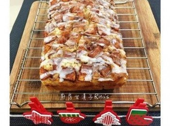 step13: 取出後直接捏住兩邊的烘焙紙將整個麵包抬起放置在烤網上，等15分鐘讓麵包略微冷卻後，烤網下面墊張鋁薄紙，淋上備好的糖霜醬即可。