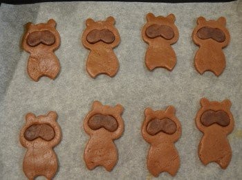 step8: 將深啡色麵糰取出，擀成約0.2厚的麵皮，用模具壓出浣熊的眼睛，然後填入淺啡色麵皮的眼部中，再用食指輕輕地壓入。