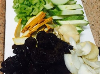 step1: 洗淨所有材料。雲耳用水浸軟。鮮百合去掉啡色部分逐瓣剝開，翠肉瓜切粗條，豆腐乾切片，西芹切幼絲。大件的秀珍菇切細。高湯、素蠔油、糖和生抽攪勻備用。