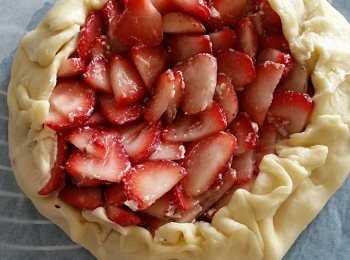 step5: 留有約1吋之麵糰，將草苺由外至內重疊形成圓形、從邊緣推疊向草苺內，形成收口、 再在麵糰上撒上白糖作裝飾及其變得較金黃