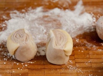 step9: 將水皮完全包著油皮，搓成球型，用掌心按壓並從中心開始上下用麵棍桿平成牛舌狀，卷起成花卷長条型麵團後待10分鐘後，再重覆做多1-2次此部驟