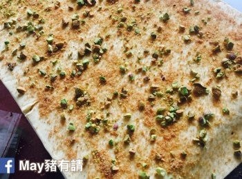 step2: 在桌上先灑上1/3份量的椰子花糖，然後鋪上酥皮。在酥皮表面再灑上1/3份量的椰子花糖和2/3份量的開心果碎。