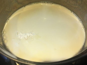 step2: 先造朱古力味部份，
先準備大碗倒入熱滾水，再用小碗載入朱古力片，放入大碗內隔水座溶。
準備小煲，先倒入淡花奶、牛奶和糖粉，小火加熱至糖融化，攪拌均勻。