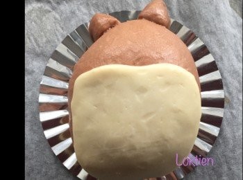 step3: 取一份白肚子麵皮，壓平至可以覆蓋在龍貓肚子的大小，在身上噴上少許水將白麵皮黏在龍貓肚子位置上。稍微用手壓一下讓麵皮緊貼在一起，繼續發酵至一倍大。