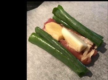 step2: 把醃好的排骨、薑片、蔥段和蒜頭放在牛油紙接近下方位置，往上卷一卷，把左右兩邊往中間摺疊，再往上卷一卷，把剩餘的紙塞進去固定。