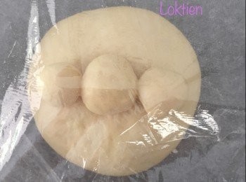 step2: 取出一份臉部的麵糰，壓平，放入紅豆蓉作為餡料後封囗，揉成圓形，放在焗盆上。

在這麵糰中間的位置，用手指輕輕按下，然後將那4 克的小麵糰塗上小許水貼在這凹洞的位置後，再將那兩份3克的小麵糰塗上小許水分別貼在鼻子的兩側。重覆至完成所有造型後，蓋上保鮮紙進行第二次發酵至1.5-2 倍大。