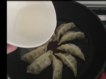 step1: 冰花其實係麵粉加水，比例好緊要，大約 1:10 我用左半匙麵粉加5匙水，餃子由急凍雪櫃取出後即放落鑊煎，冚蓋煎3分鐘後倒入麵粉水，我果個係小鑊，如果用大鑊，麵粉水就要多啲，麵粉水要覆蓋成個鑊底，待收乾水後就會形成冰花狀，全程用中小火煎餃