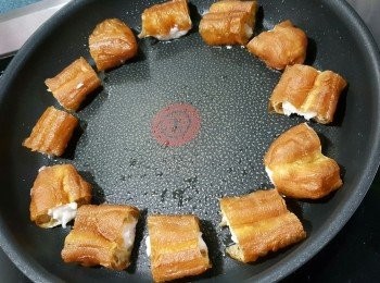step4: 用平底易潔鑊，凍鑊落少許油，將油煮熱，放入已經釀好墨魚滑的油炸鬼，墨魚滑向下，用慢火將墨魚滑煎至金黃