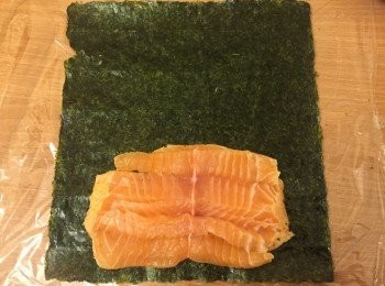 step2: 魚柳取出後，用蝶切法，盡量攤開整件魚柳。
再鋪好保鮮紙及紫菜，放上魚柳。