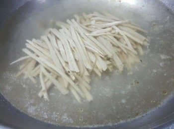 step5: 處理素雞絲及粉皮方法：先用水煮滾，落一粒素雞精及一茶匙鹽將素雞煮約2分鐘待素雞絲入味,取出後再放入已經浸軟的粉皮,煮到粉皮透明即可取出,粉皮約煮5分鐘