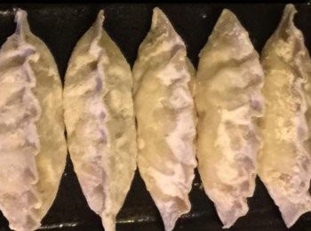 step2: 將麵糰由缽盆取出，放在平枱上撒一㸃麵粉，然後搓成一小條，再用刀仔切成小塊， 用手掌根壓成一塊 後，用麵棍將一塊塊的小麵糰擀一個圓型狀的餃子皮。

再將饀料放入餃子皮內，打摺及 用手指將皮壓合再摺邊，而包好的餃子排列在碟上待用。