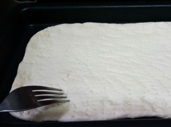 step4: 將麵團推開成長形，放在掃佐油的平烤盆上，用叉子叉滿小孔