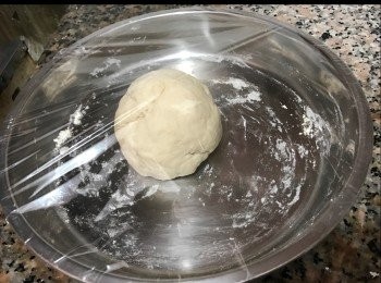 step5: 拿出麵團，搓成長條，把麵團分割為8至10等份。每個小麵團滾圓，然後用木棍壓扁。用匙羹把適量的餡放上皮上包好。放置室溫中，發酵10分鐘。