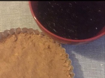 step2: 將餅亁碎屑倒入碗中，加入熔解了的牛油。用力攪均後，將餅亁碎屑壓在批盤內，慢慢將餅亁碎屑壓成批形狀的批殻，然後放入雪櫃內冷藏45分鐘。