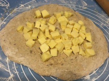 step3: 麵糰要加多些高筋麵粉至不沾手。然後將麵糰壓平一些，再放芝士粒在上面。