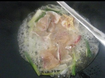 step6: 加入鯇魚片略撥平，（ 不可亂兜炒 ）煮至鯇魚片底部呈白色，用鑊摌輕輕將鯇魚片反轉，煮至呈白色，約九成熟，加入包尾麻油，熄火。