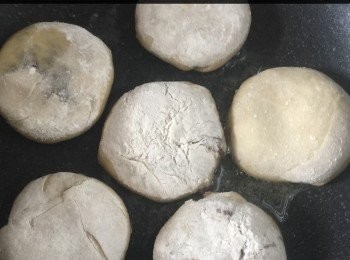 step6: 再將這條麵糰切成一塊塊，用手壓成圓形的外皮（如果外皮太濕可加入少許麵粉再搓），然後先至填入2湯匙的<span class="group_2">餡料</span>。將<span class="group_1">餡皮</span>對摺，再搓成圓形狀，像個小球。用手將<span class="group_1">餡皮</span>面壓一下便成盒子形狀。