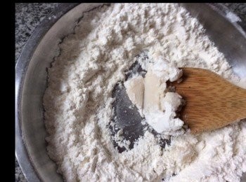 step6: 熟麵粉95克十梳打粉1克拌勻，在碟內開成麵窩，中間加入豬油，將糖水加入，邊加邊用木杓攪拌至均勻，要快手攪拌因麵粉好易結粒，搓至成麵糰。