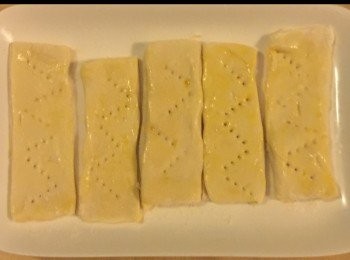 step1: 首先將烤箱预熱至 210攝度。

將酥皮卷切開一半，然後將酥皮卷切成10條長形狀，然後於每一條再放多一條於上面。