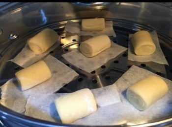 step4: 1）取出，哂低筋麵粉工作槕上
2）排氣，搓成長方型，摺三摺
3）再搓成長方型，用熟水塗面，卷條，切件
4）發酵30分鐘，旁邊放一杯熱水，幫助發酵