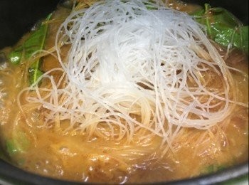 step4: 燒紅煲，加入少許油，中火將南薑，及冬蔭功醬炒約2-3分鐘，加入香茅及檸檬葉炒香，倒入椰青水及椰糖煮滾，放入粉絲拌匀，中小火煮約5分鐘，加入大蜆蓋上煲蓋中火煮約4分鐘至大蜆打開，打開煲蓋轉中大火把水份收至乾身，熄火；灑上青檸汁及魚露調味，伴上金不換及紅辣椒裝飾，即成。