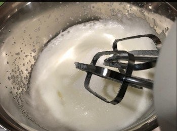 step5: 於雪櫃將蛋白拿出，用打蛋器將蛋白打至有勾，砂糖分三次加入，期間可以加入班蘭香油