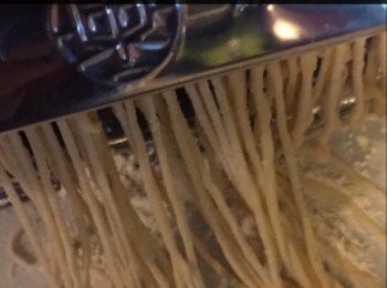 step4: 準備壓麵機，教好要壓出麵糰的厚度，把麵糰略壓平放入壓麵機，經兩、三次的重覆的壓出如薄紙一般，再通過麵機，壓出麵條出來，並立即撒一些麵粉於麵條上備用。