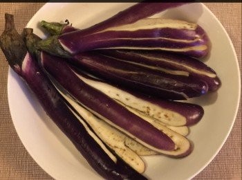 step2: 將茄子洗淨，並於茄士身上切多條長型狀的線條，但不要切斷，保留茄子頂的部份，用少許鹽和胡椒粉混合調勻片刻備用。