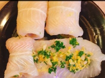 step2: 用乾布或廚房紙巾抹乾魚身。以少許鹽和胡椒粉調味3 分鐘，然後將蒜蓉，芫茜，檸檬皮和汁及牛油攪勻，塗於魚身上，鋪上一層薄薄的蒜蓉檸檬汁及牛油，然後由魚尾開始卷起鱼片。無需要用牙簽去把魚放在一起。它亦能保持卷形状，因為魚身夠坦。