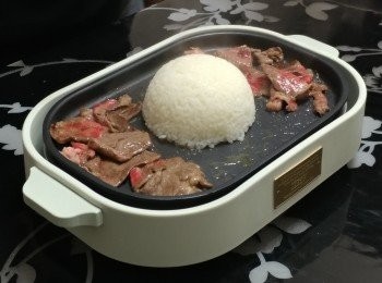 step3: 將牛肉片推往烤盤的兩邊; 下熱飯在烤盤中央， 稍為壓平