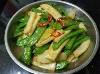 step5: 先將炸魚片用蒜頭 , 乾蔥煎香上碟 , 再爆香蒜頭 , 乾蔥 , 薑片爆炒荷蘭豆 , 炒至開始轉翠綠後 , 加少少黃酒 , 雞粉 , 糖輕炒 , 再放入魚片 , 加少少水滾起後 , 加少少麻油 , 完成 .