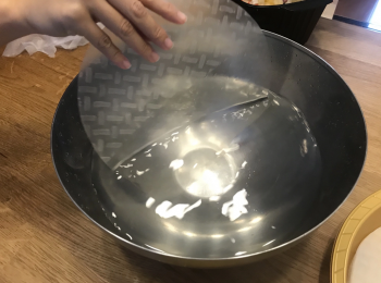 step3: 將米紙放在暖水浸約5秒然後撈起，此時米紙會由一塊硬崩崩狀態變成軟塊。