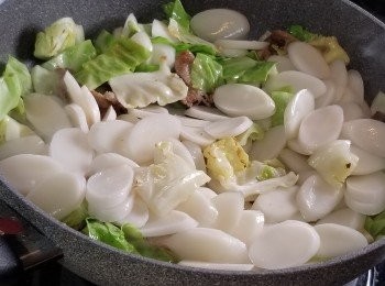 step5: 再將年糕片加入炒勻後,加入適量水份燴煮一會。